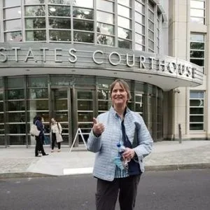 Susan Dones stands outside of the US Courthouse where Keith Raniere was convicted and sentenced. Dones spoke at his sentencing and the judge added abo