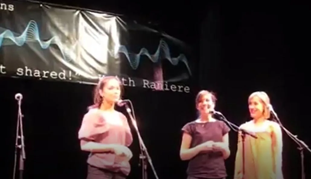 Picture says 1000 words: Kristin Kreuk, Mack onstage with Raniere banner behind