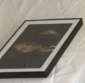 A discarded picture of worshipful Keith Raniere. Left on an empty mattress at Silver Bay. It was once venerated and hung on walls during V-Week in devotees rooms.