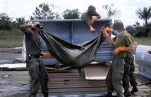 US military personnel place a body bag containing the remains of a victim of the Jonestown tragedy in a coffin for transport to Dover Air Force Base, Delaware.
