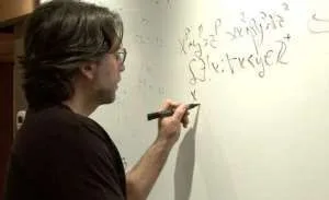 Raniere sketching out formulas in his library.