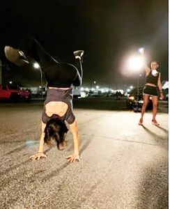 Danielle Roberts does a handstand outside the Metropolitan Detention Center as Michele Hatchette dances for Keith Raniere and other prisoners there. Attorney Neil Glazer has asserted in a court filing that Hatchette revealing the names of plaintiffs is virtually the same as defendants Roberts, Clyne or Porter for she is their associate.