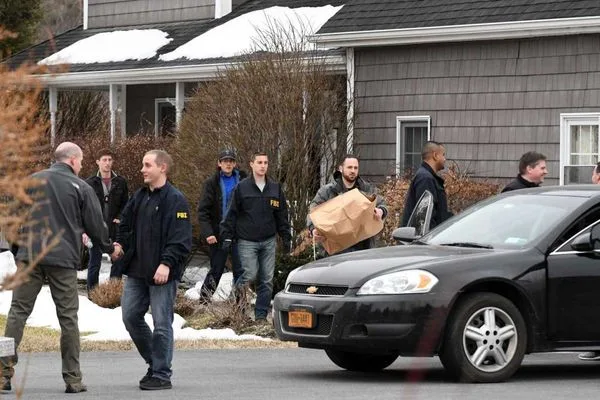 FBI Special Agent Michael Lever (L) conducting a raid on Nancy Salzman's house.