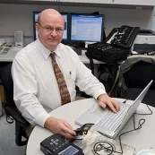 Computer Forensics expert Stephen Bunting, Public Safety works to extract information on a cell phone for analysis.
