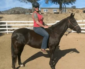 Michelle Knuttila on horseback at HiCaliber Horse Rescue.