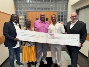 4 men and one woman holding enlarged charity checks
