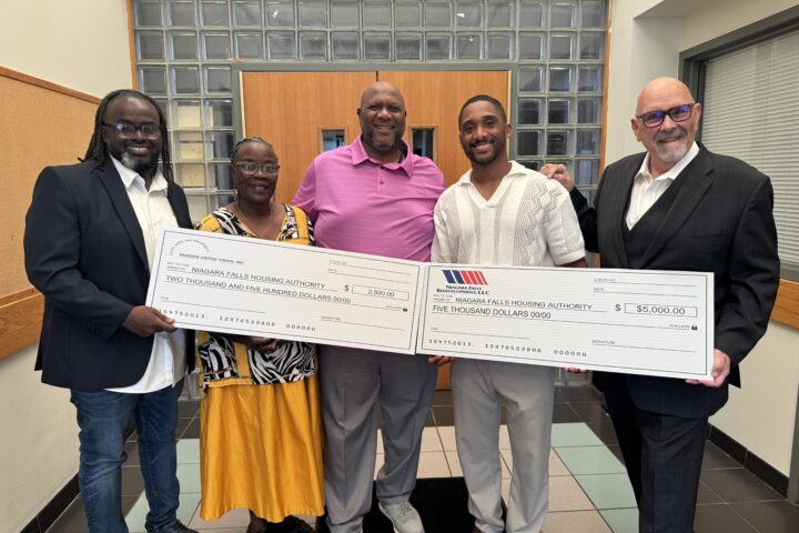 4 men and one woman holding enlarged charity checks