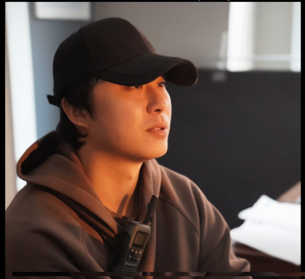 Portrait of Hao Yan looking off to the distance in black hat