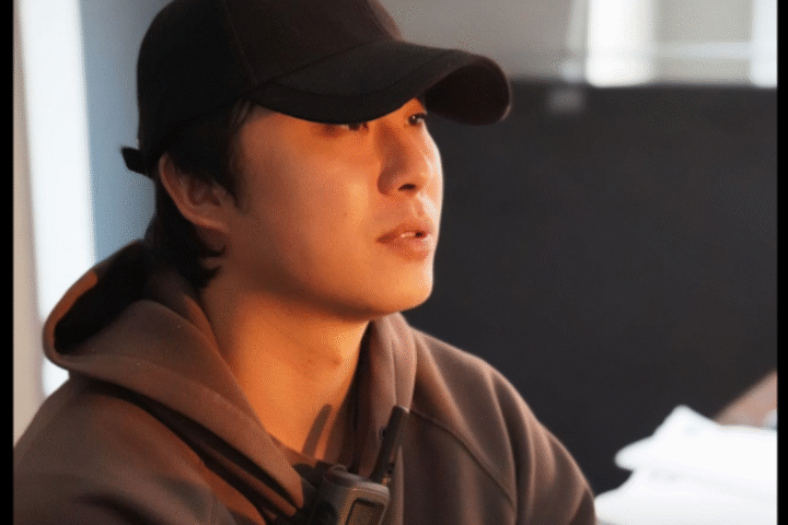 Portrait of Hao Yan looking off to the distance in black hat